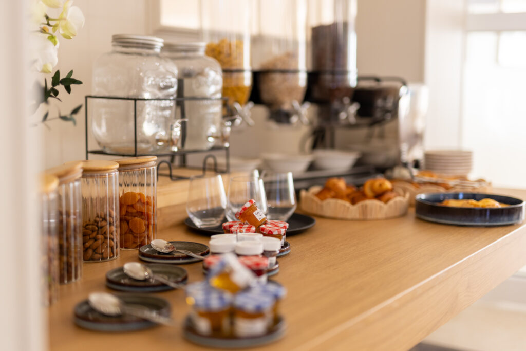 buffet petit-déjeuner avec fruits frais, fromages, charcuterie et boissons chaudes